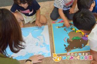 モンテッソーリ教育のアジアの地図パネルの活動をする子供